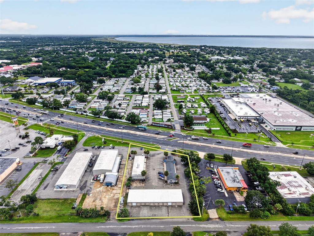 An aerial view shows a commercial property with multiple buildings and parking lots near a highway — 3207 13TH STREET, ST CLOUD, FL