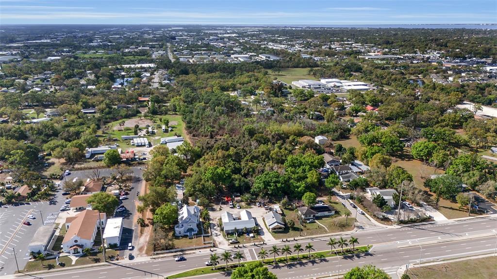 An aerial view shows a suburban area with a church, houses, and a multi-lane road — 2008 53RD AVENUE E, BRADENTON, FL