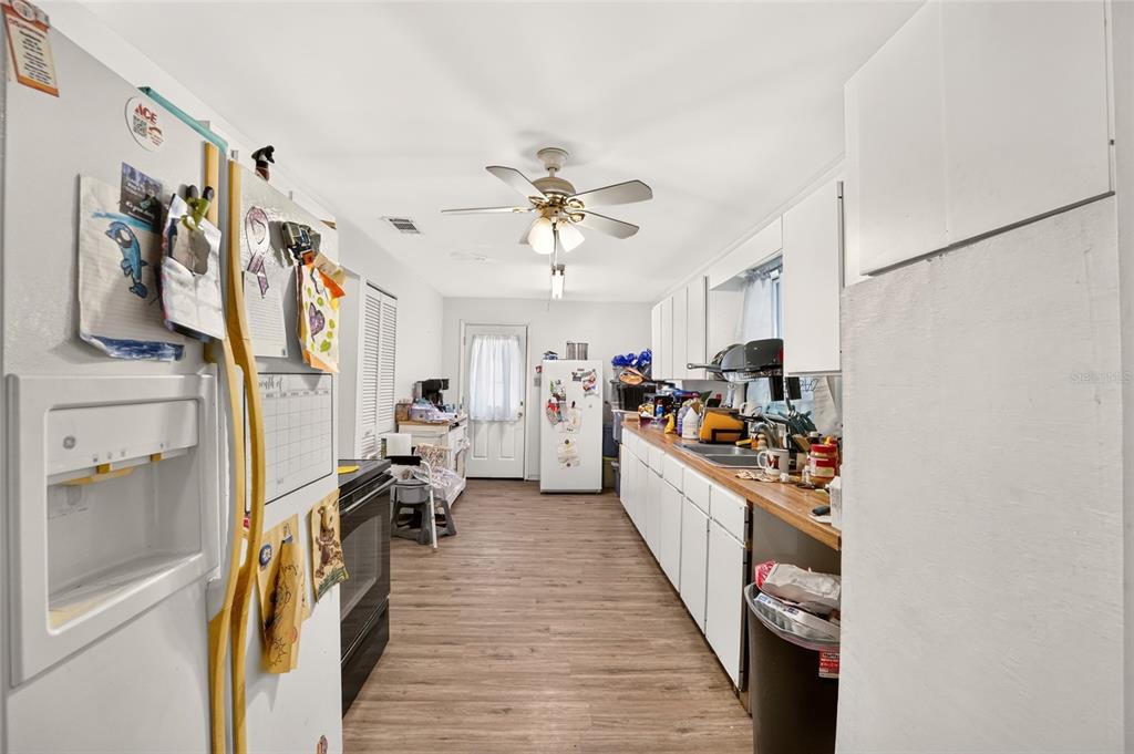 A dining room features black walls, hardwood floors, a wooden table, and a ceiling fan — 7020 SE 221ST STREET, HAWTHORNE, FL