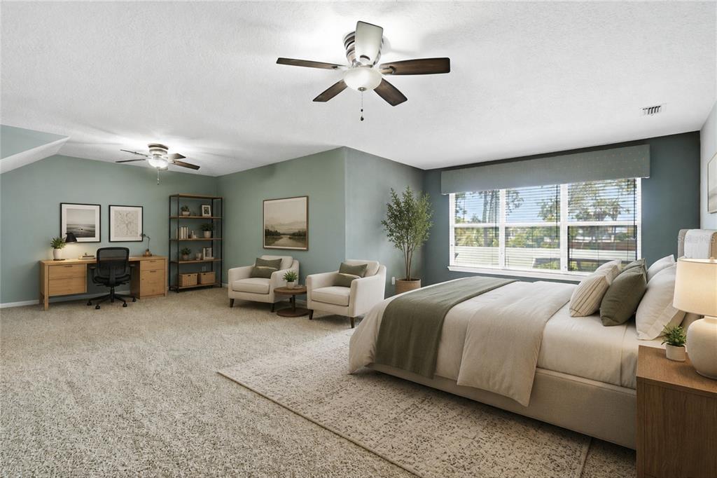 A spacious bedroom features a bed, two armchairs, a desk, and a ceiling fan — 1413 COURSE VIEW, FLEMING ISLAND, FL