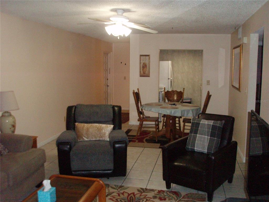 A living room with tile floors, a ceiling fan, and an adjacent dining area — 4500 E BAY DRIVE UNIT 138, CLEARWATER, FL