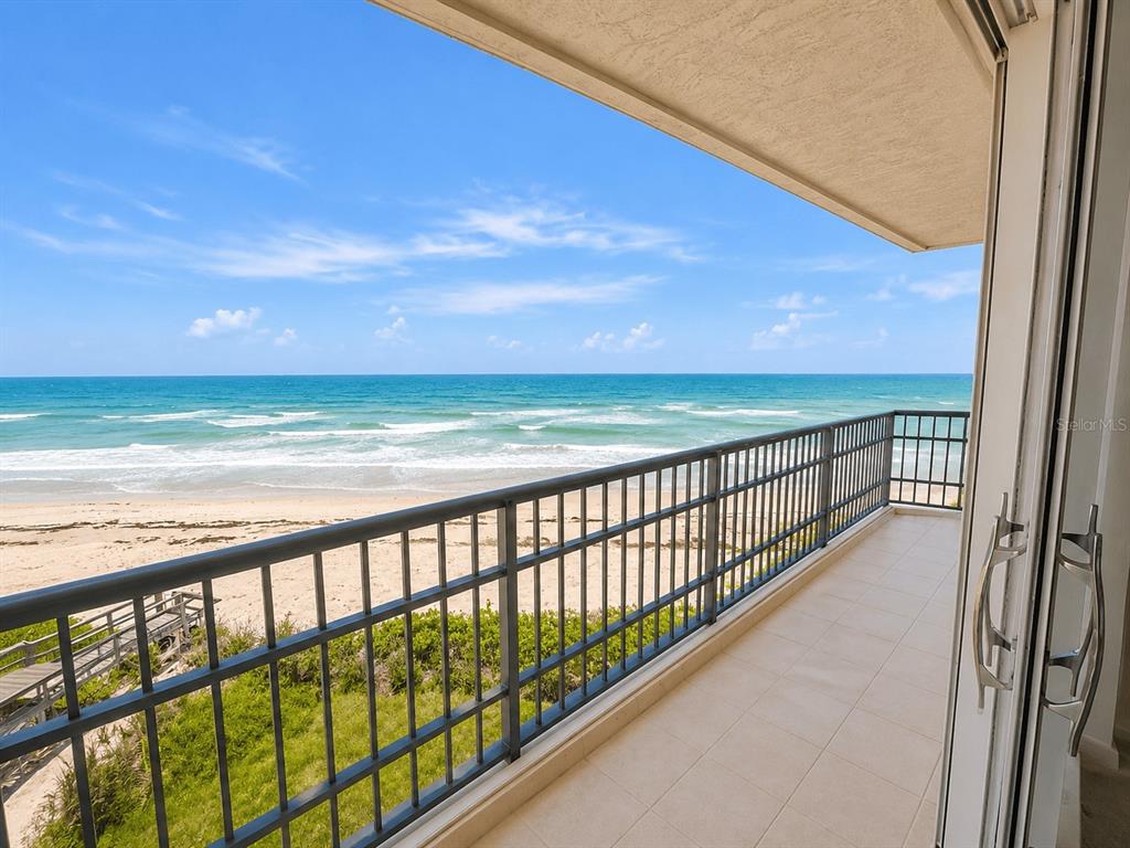 A balcony with a metal railing overlooks a sandy beach and the ocean — 8600 S OCEAN DRIVE UNIT 402, JENSEN BEACH, FL