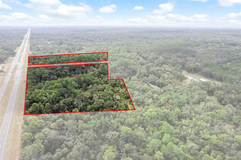 An aerial view shows two wooded land parcels outlined in red next to a highway — 11570 W GARNET COURT, CRYSTAL RIVER, FL