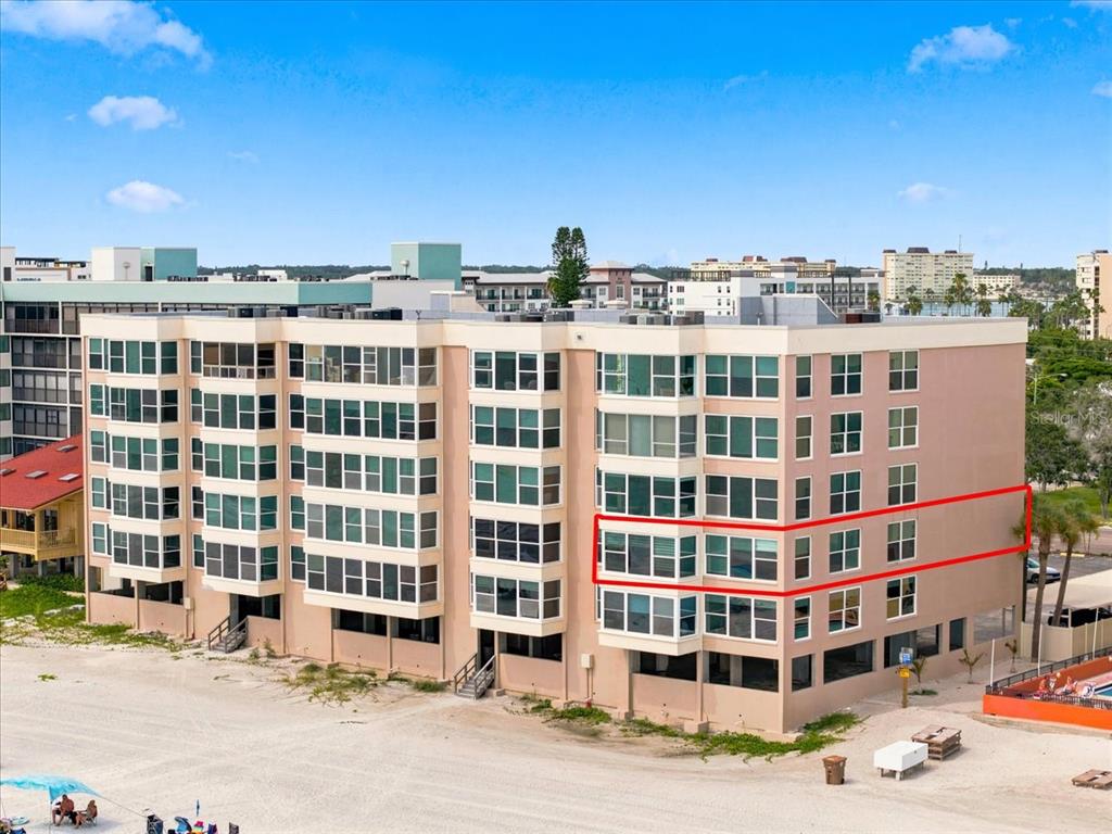 An exterior view of a multi-story beachfront condominium building with a red outline highlighting units — 14800 GULF BOULEVARD UNIT 207, MADEIRA BEACH, FL