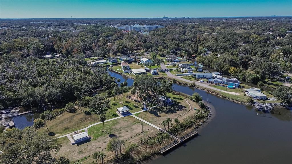 An aerial view shows a park with a pavilion and walkways beside a winding river — 8615 PARKWAY CIRCLE, RIVERVIEW, FL