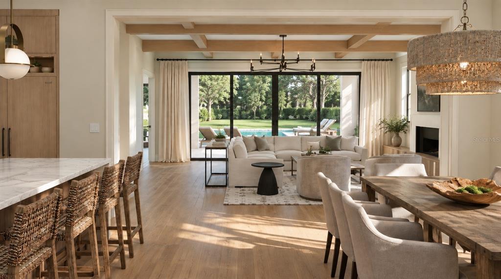 An open-concept living and dining area features wood beams, a pool view, and neutral furniture — 2119 HOWARD DRIVE, WINTER PARK, FL
