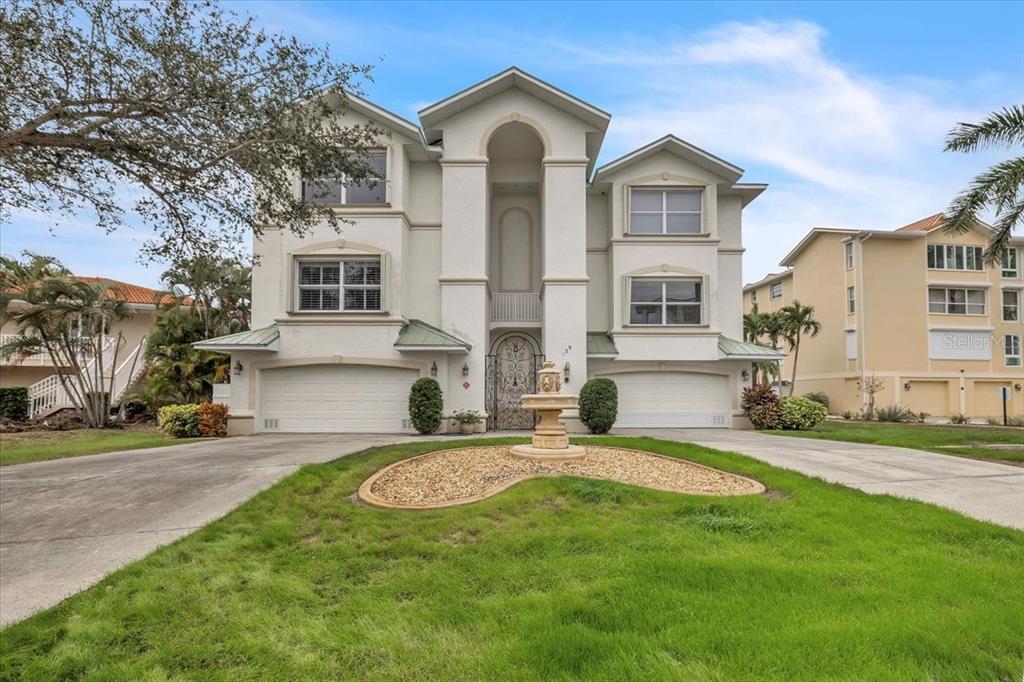 A two-story house with a central fountain, two garages, and a decorative metal front door — 129 BREAKERS COURT UNIT 121, PUNTA GORDA, FL