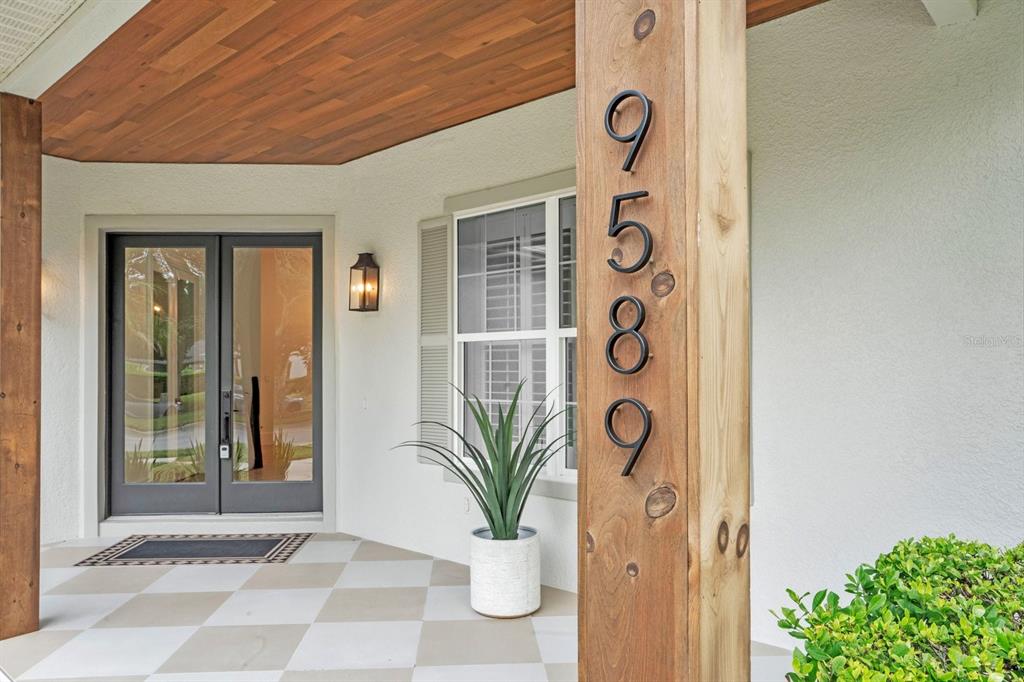 A single-story house with a covered entryway, palm trees, and a concrete walkway — 9589 PINE LILY STREET, ORLANDO, FL
