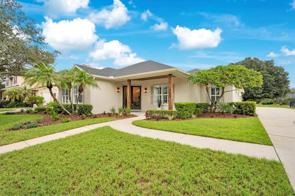 A covered front porch features a checkered floor, wood-paneled ceiling, and double glass entry doors — 9589 PINE LILY STREET, ORLANDO, FL