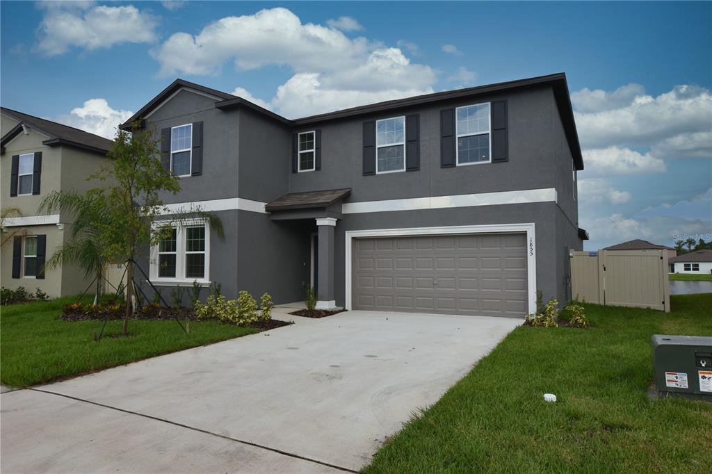 A two-story gray house with a two-car garage and a concrete driveway — 1855 RED LOOP, LAKELAND, FL