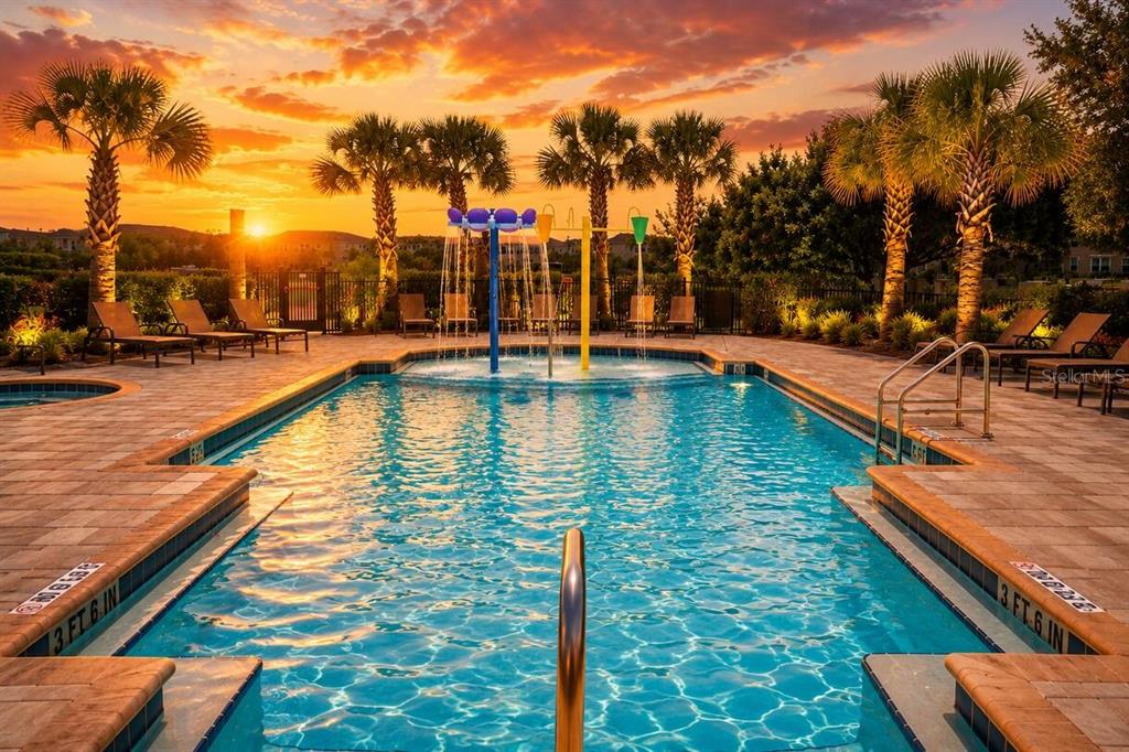 A swimming pool with a water feature and palm trees at sunset — 184 VILLA DOMANI CIRCLE, DAVENPORT, FL