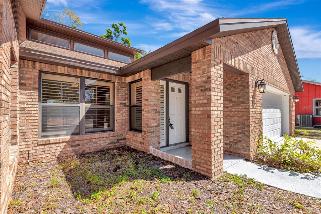 A brick exterior house features a front entrance, a garage, and a landscaped yard — 5017 80TH AVENUE CIRCLE E, SARASOTA, FL