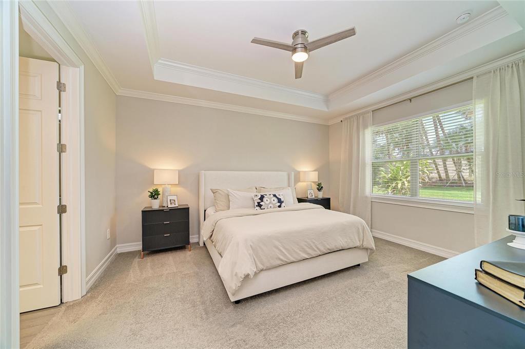A bedroom features a tray ceiling, a ceiling fan, a bed, and a large window — 288 SOLIERA STREET, NOKOMIS, FL