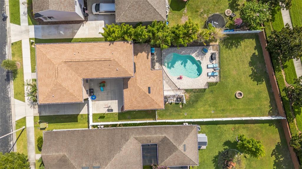 An aerial view shows a house with a swimming pool, patio, and fenced backyard — 32630 COLDWATER CREEK LOOP, WESLEY CHAPEL, FL