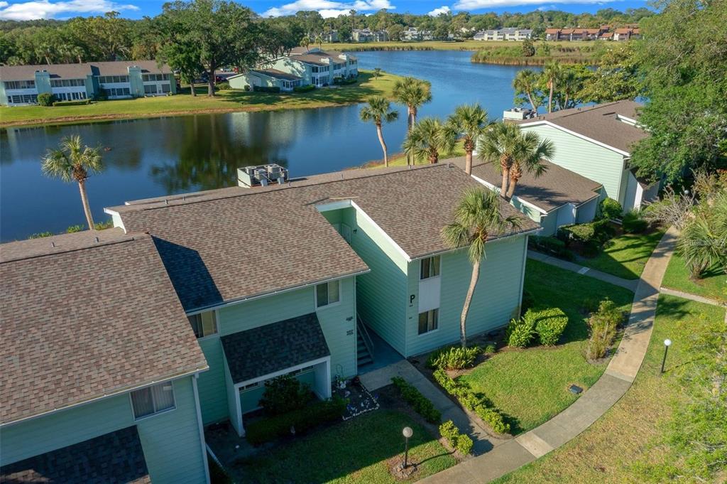 An aerial view of a light green apartment building with a lake in the background — 515 MIDWAY DRIVE UNIT A, OCALA, FL