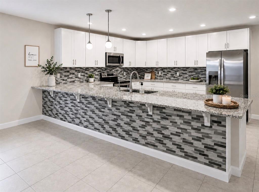 A kitchen features white cabinets, granite countertops, stainless steel appliances, and a tiled breakfast bar — 4814 CORAL CASTLE DRIVE, KISSIMMEE, FL