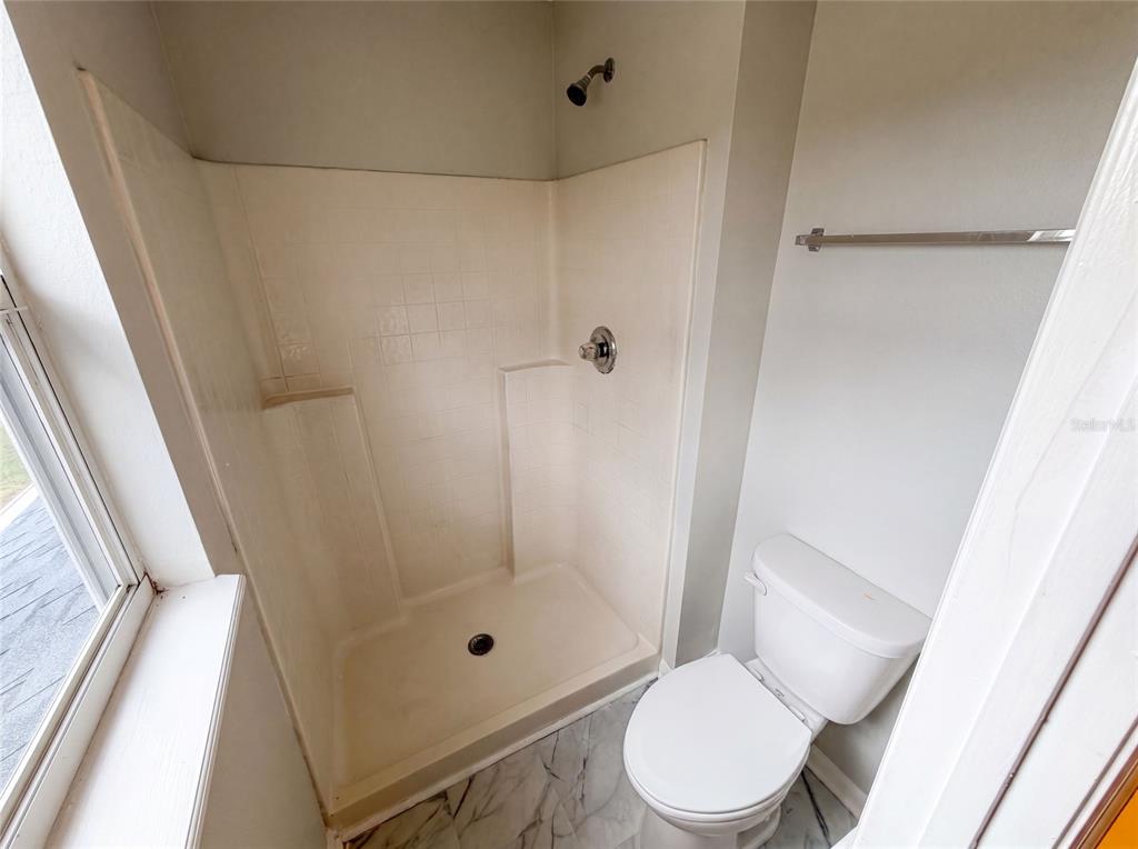 A room with light gray walls, a ceiling fan, and white marble-patterned tile flooring — 5191 QUINTILIS STREET, SPRING HILL, FL