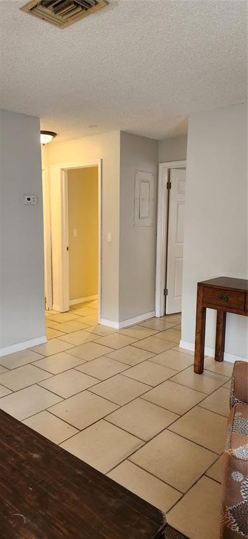 A tiled hallway leads to two doorways in a room with light gray walls — 5004 AVERY ROAD, NEW PORT RICHEY, FL