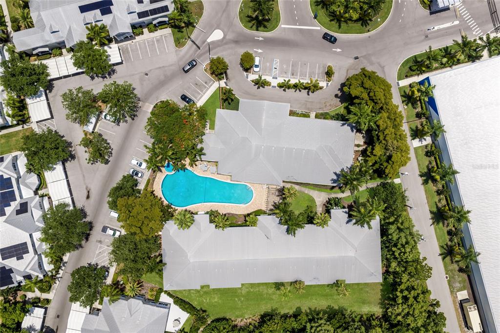 Aerial view of a community clubhouse with a swimming pool and surrounding parking lots — 3506 54TH DRIVE W UNIT 106, BRADENTON, FL