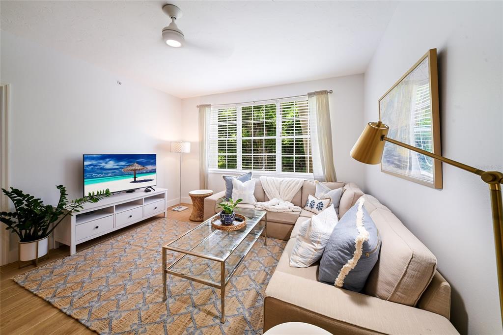 A living room features a beige sectional sofa, glass coffee table, and a white media console — 3506 54TH DRIVE W UNIT 106, BRADENTON, FL