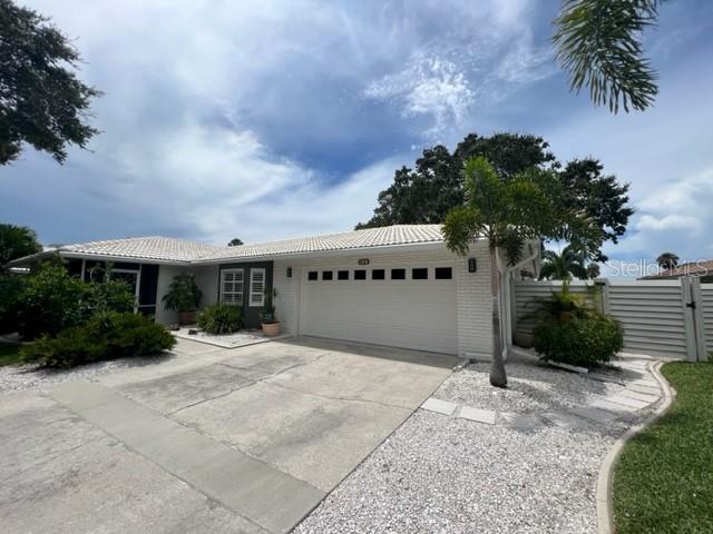 A single-story house with a white brick exterior, a two-car garage, and a palm tree — 7328 CURTISS AVENUE, SARASOTA, FL