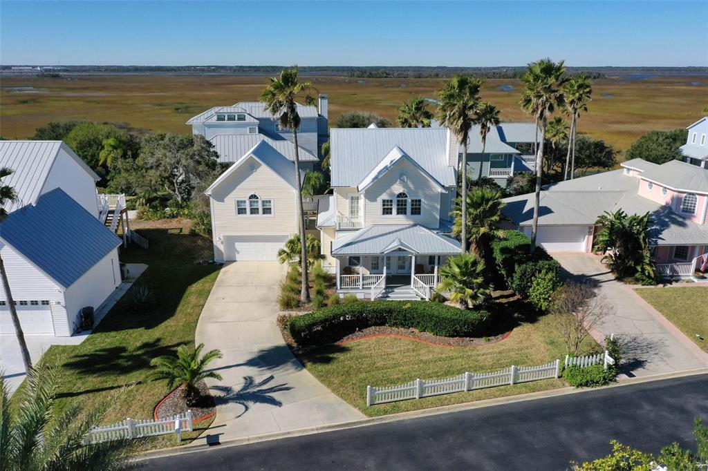 An aerial view of a yellow two-story house with a metal roof and palm trees — 252 GULL CIRCLE, PONTE VEDRA, FL