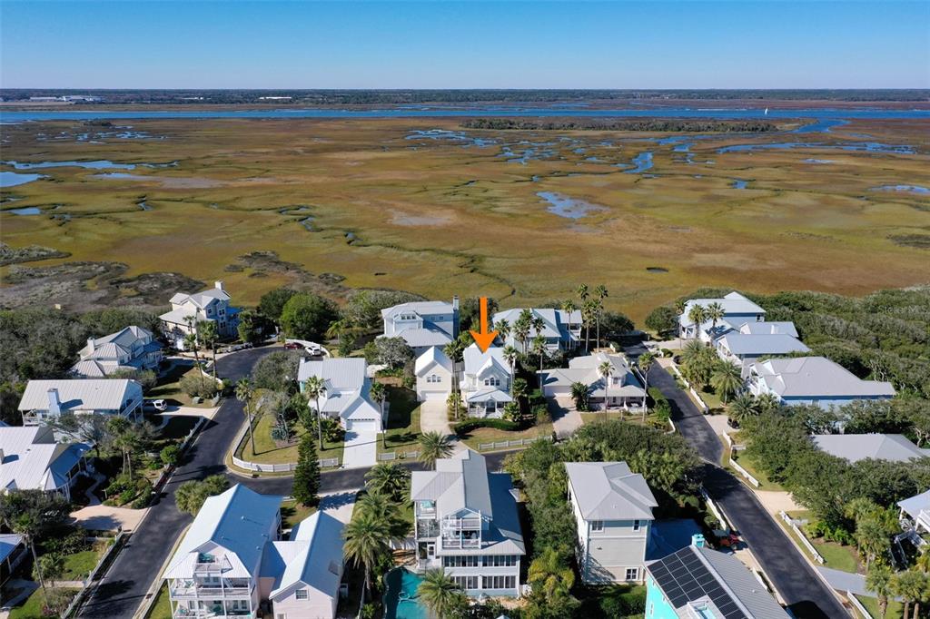 An aerial view shows a coastal neighborhood with houses situated near a large salt marsh — 252 GULL CIRCLE, PONTE VEDRA, FL