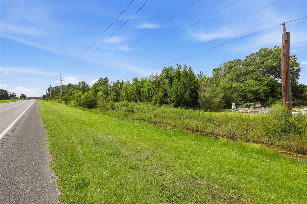 A grassy roadside area with a drainage ditch, utility poles, and a line of trees — 19978 N HIGHWAY 301, STARKE, FL