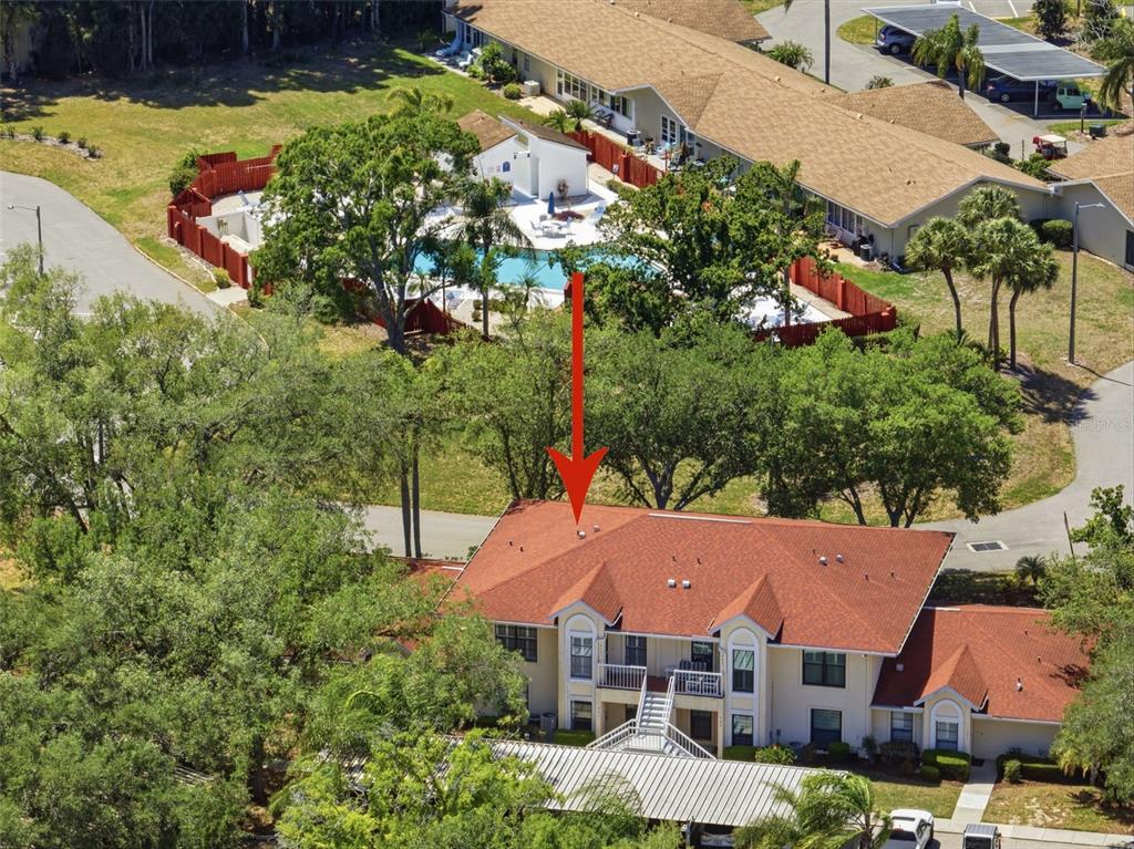 An aerial view of a multi-story residential building with a red roof near a pool — 309 KNOTTWOOD COURT UNIT 309, SUN CITY CENTER, FL