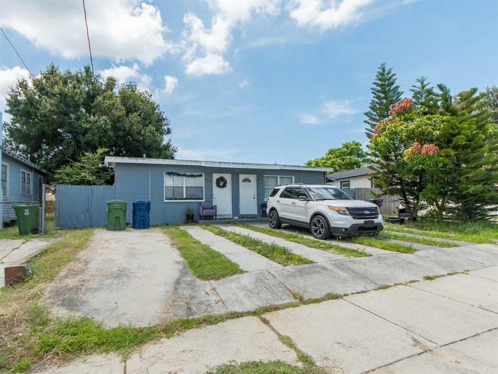 A single-story blue house with a white SUV parked on a concrete driveway — 2532 W WALNUT STREET, TAMPA, FL