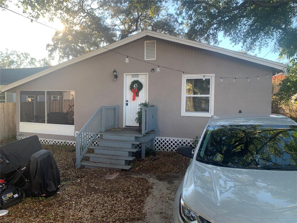 A gray house with a front porch, stairs, and a white door with a wreath — 1880 SYLVAN DRIVE, CLEARWATER, FL