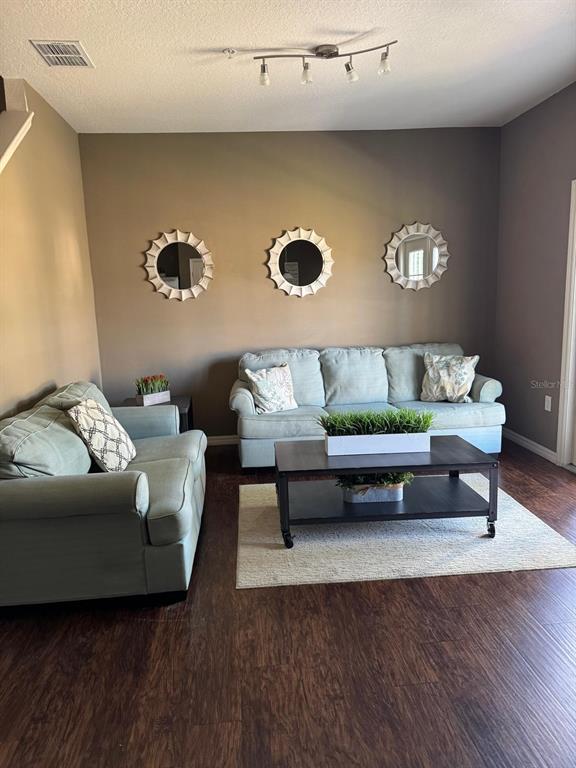A living room features two light blue sofas, a coffee table, and three circular wall mirrors — 8981 SHINE DRIVE, KISSIMMEE, FL