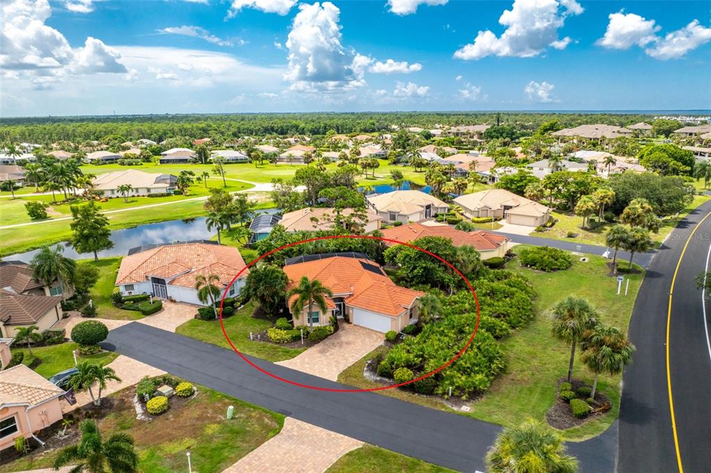 An aerial view shows a single-story house with a red tile roof and paved driveway — 3901 CAPE COLE BOULEVARD, PUNTA GORDA, FL
