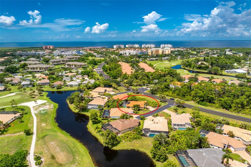 An aerial view of a residential neighborhood with a red circle highlighting a single-family home — 3901 CAPE COLE BOULEVARD, PUNTA GORDA, FL