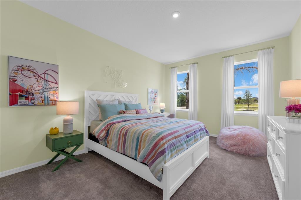 A bedroom features a white bed, a green nightstand, and a pink beanbag chair — 5824 CLIFFBOW LOOP, LEESBURG, FL