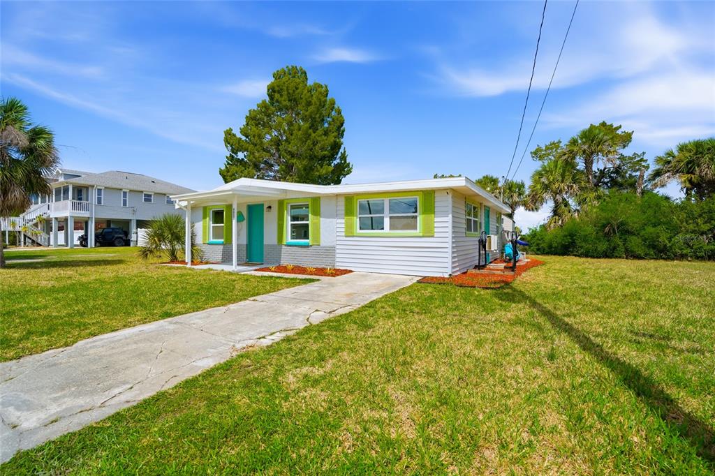A backyard features a storage shed, a patio with a blue shade sail, and bicycles — 4021 EAGLE NEST DRIVE, HERNANDO BEACH, FL