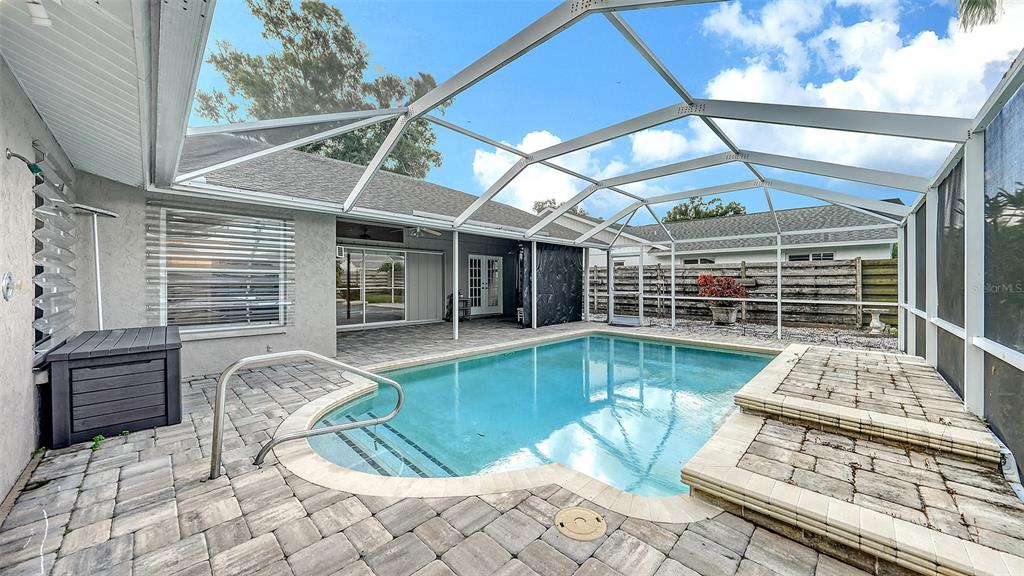 A screened-in swimming pool with a paver deck and a covered patio area — 4494 DIAMOND CIRCLE E, SARASOTA, FL
