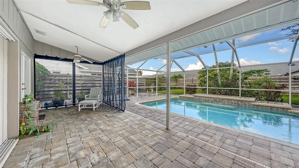 A covered patio with a pool, stone pavers, and a screened-in enclosure — 4494 DIAMOND CIRCLE E, SARASOTA, FL