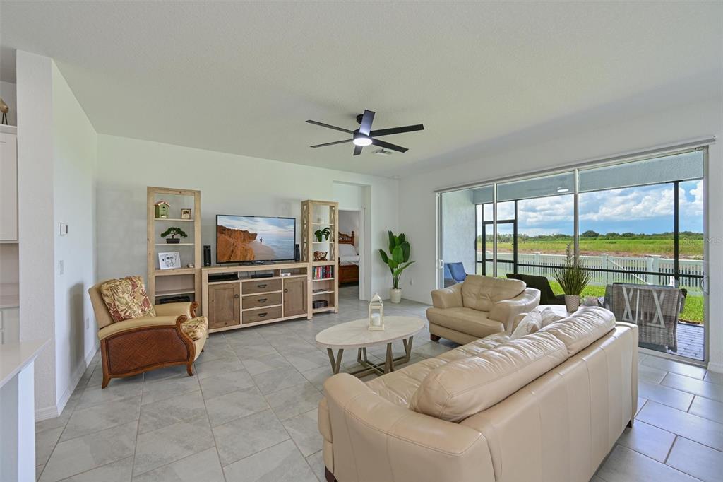 A living room with tile floors, a television console, and sliding glass doors to a patio — 3519 NIGHT STAR TERRACE, PARRISH, FL