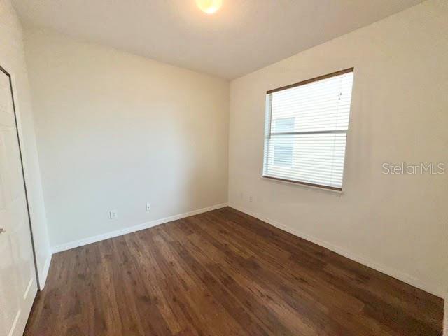 An empty bedroom features white walls, a window with blinds, and wood-look flooring — 4301 HEIRLOOM ROSE PLACE, OVIEDO, FL