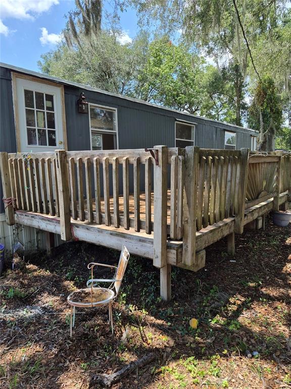 A wooden deck with railings is attached to the side of a dark-sided mobile home — 9285 SE 140TH PLACE, SUMMERFIELD, FL