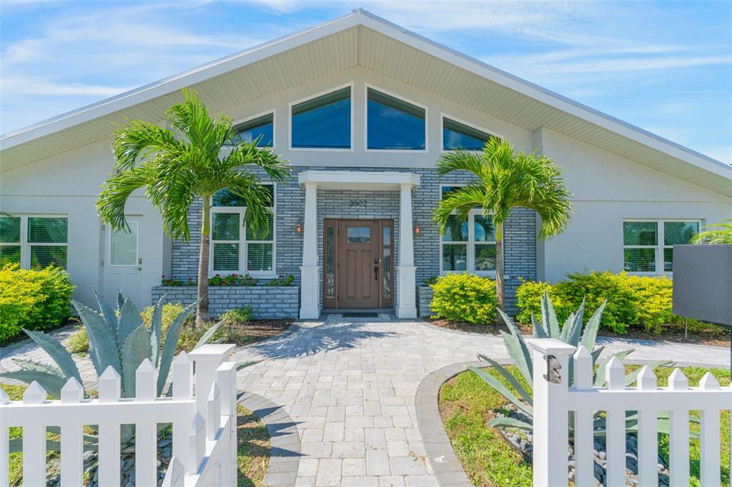 A single-story house with a gray brick facade, white trim, and a paved walkway entrance — 3502 BAHIA VISTA STREET, SARASOTA, FL