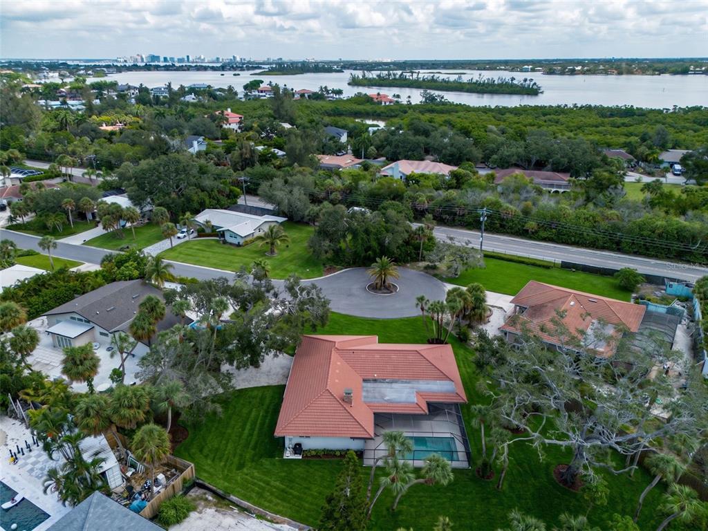 An aerial view shows a residential neighborhood with houses, a cul-de-sac, and a nearby bay — 670 VENICE LANE, SARASOTA, FL