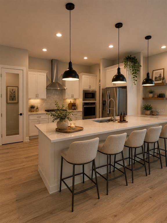 A modern kitchen features white cabinetry, a large island with bar seating, and pendant lighting — 5601 SUMMIT VIEW DRIVE, BROOKSVILLE, FL