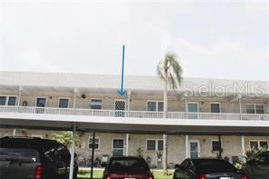 A multi-story apartment building exterior features a covered parking area and a second-floor balcony — 5357 81ST STREET N UNIT 24, ST PETERSBURG, FL