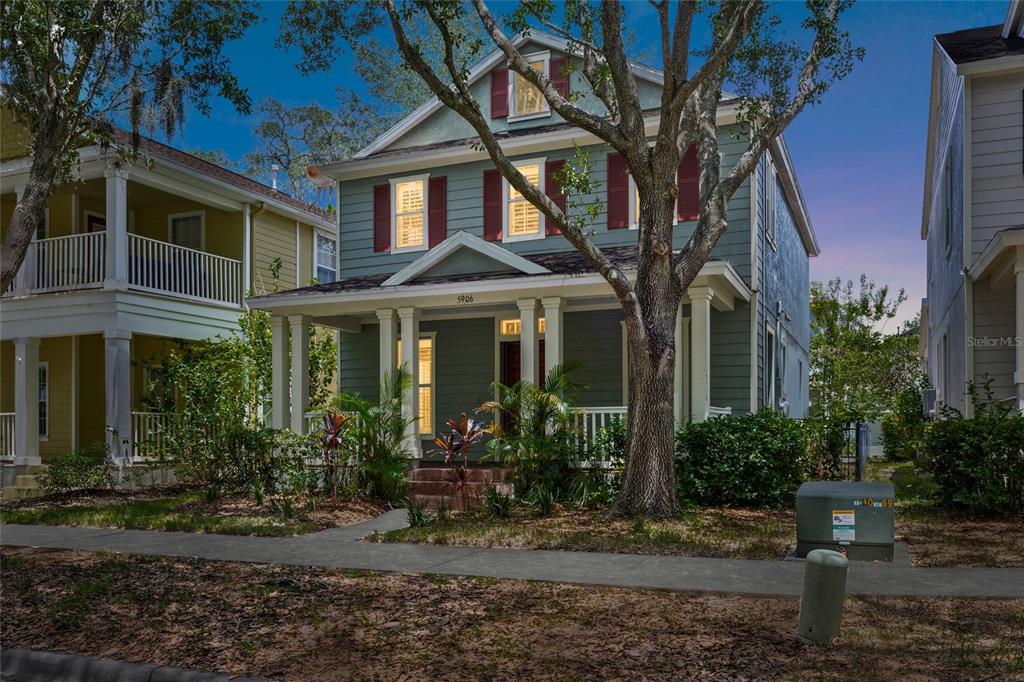 A two-story house with green siding, red shutters, and a front porch stands outdoors — 5906 BEACONPARK STREET, LITHIA, FL