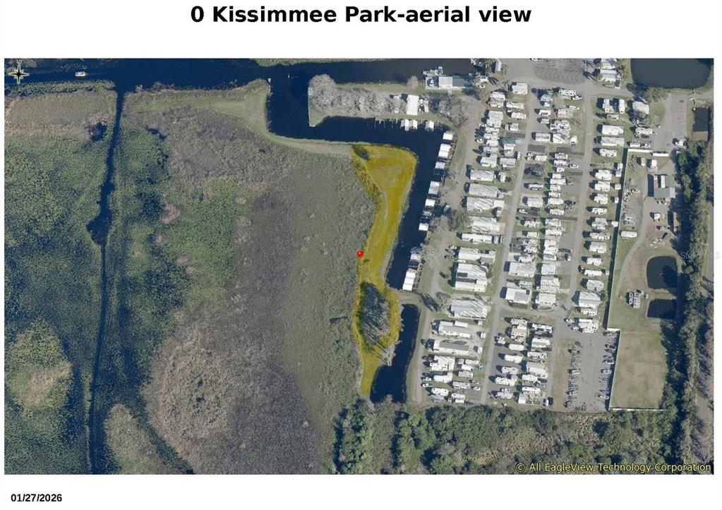 An aerial view shows a grassy lot adjacent to a canal and a mobile home park — KISSIMMEE PARK ROAD, ST CLOUD, FL
