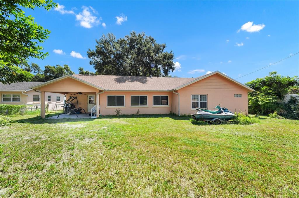 The exterior of a peach-colored single-story house features a covered patio and a grassy yard — 3126 S OSCEOLA AVENUE, ORLANDO, FL