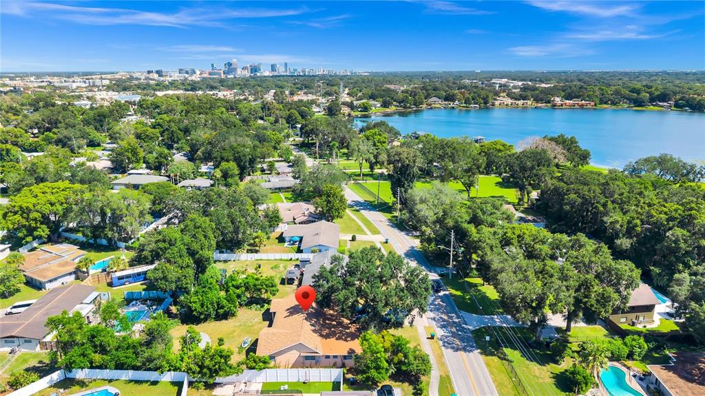 An aerial view shows a residential house with a red pin, surrounding trees, and a lake — 3126 S OSCEOLA AVENUE, ORLANDO, FL