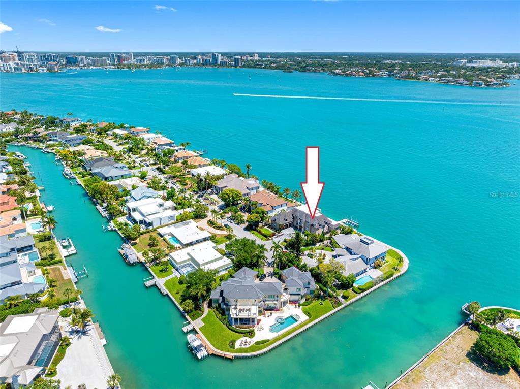 An aerial view shows a waterfront residential property with a pool on a peninsula — 487 MEADOW LARK DR, SARASOTA, FL